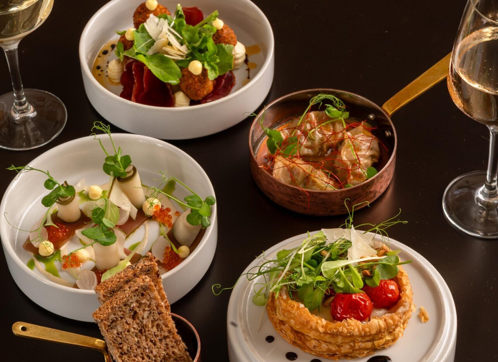 Elegant gourmet dishes served on black table at Palm House Boutique Hotel and Spa, showcasing fine dining experience inspired by The Spice Route Experience.